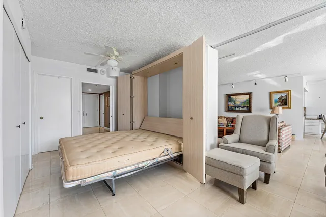 a spacious bedroom with a bed and ceiling fan