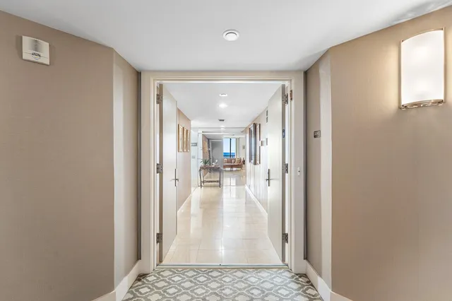 a view of a hallway with wooden floor and a livingroom