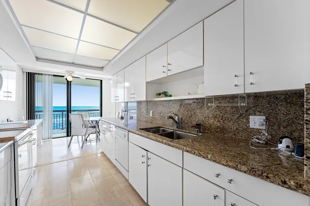 a kitchen with granite countertop a sink a stove and cabinets