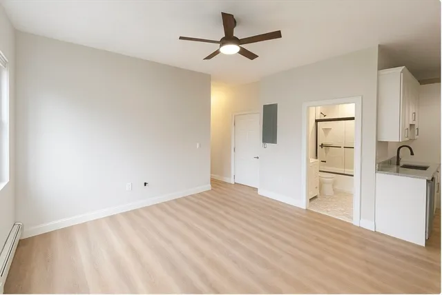 a view of a livingroom with wooden floor and a ceiling fan