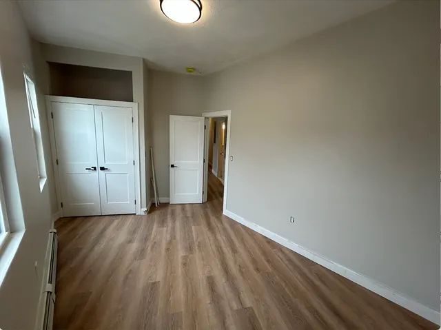 an empty room with wooden floor and closet