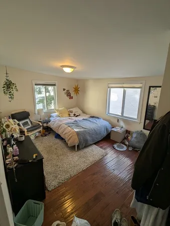 a bedroom with a bed and wooden floor