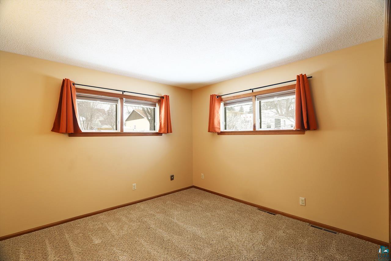 811 7th Street North Virginia, MN 55792 - Photo 15 of 37 Carpeted spare room featuring plenty of natural light and a textured ceiling