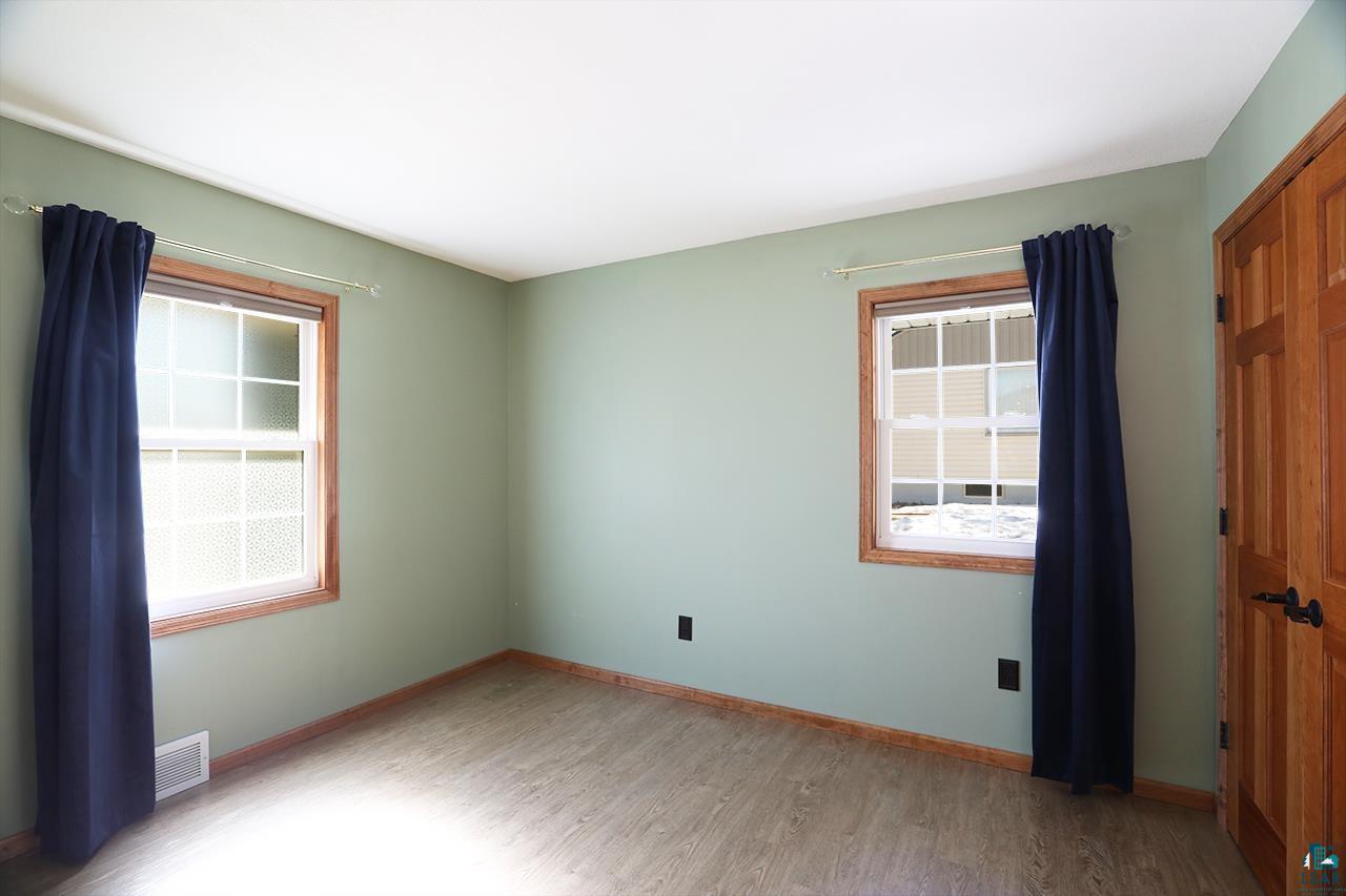 811 7th Street North Virginia, MN 55792 - Photo 22 of 37 Unfurnished bedroom featuring a closet, light wood finished floors, and multiple windows