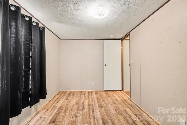 a view of a bedroom with wooden floor and a window