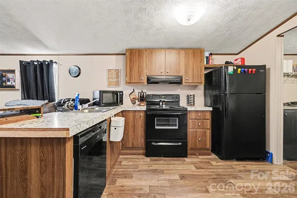 a kitchen with stainless steel appliances kitchen island granite countertop a refrigerator stove and oven