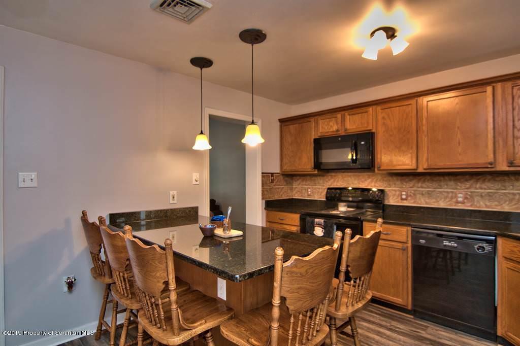 212 Summit Woods Road Moscow, PA 18444 - Photo 14 of 68 a kitchen with a table chairs microwave and stove