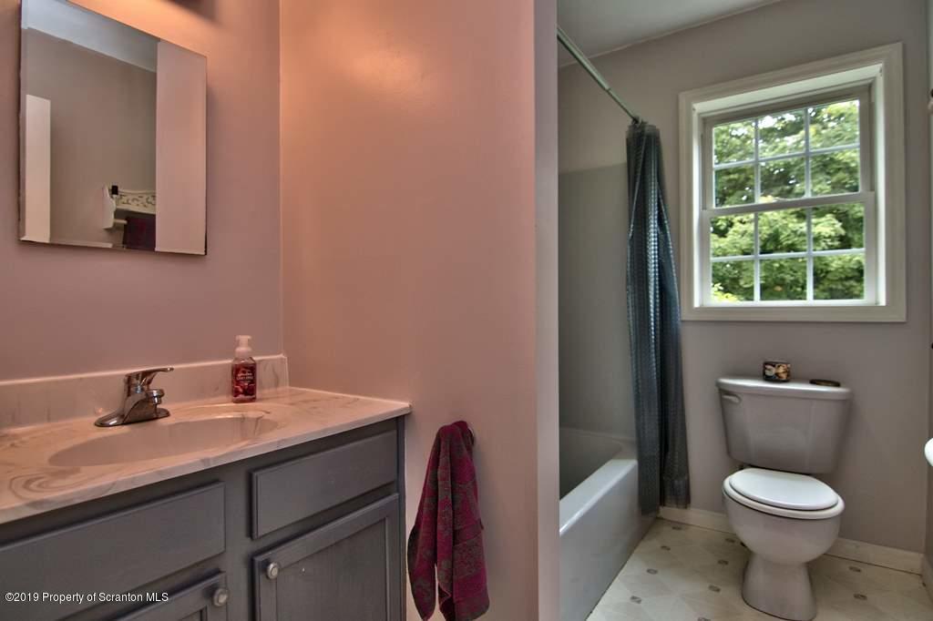 212 Summit Woods Road Moscow, PA 18444 - Photo 21 of 68 a bathroom with a toilet a sink and mirror