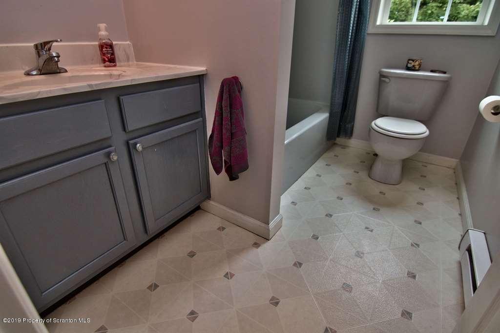 212 Summit Woods Road Moscow, PA 18444 - Photo 22 of 68 a bathroom with a toilet sink and mirror