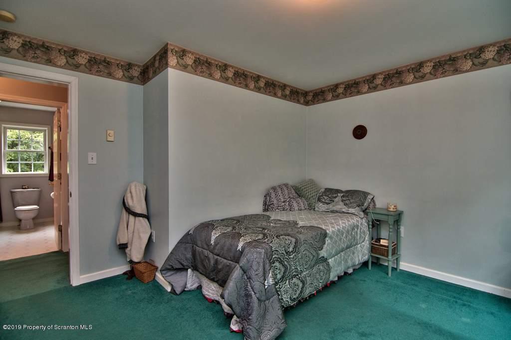 212 Summit Woods Road Moscow, PA 18444 - Photo 24 of 68 a bedroom with a bed and a mirror
