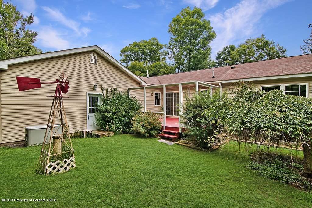 212 Summit Woods Road Moscow, PA 18444 - Photo 3 of 68 a view of a backyard with plants and a garden