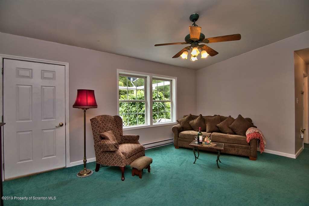 212 Summit Woods Road Moscow, PA 18444 - Photo 5 of 68 a living room with furniture and a chandelier