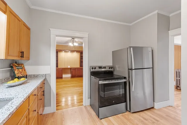 a kitchen with a refrigerator stove and wooden cabinets