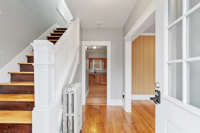 an entryway with wooden floor and windows