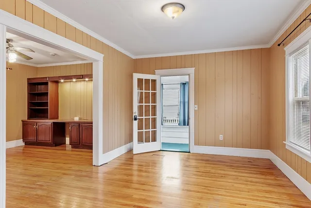 an empty room with wooden floor and windows