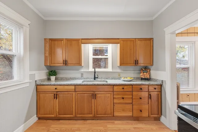 a kitchen with a sink window and cabinets