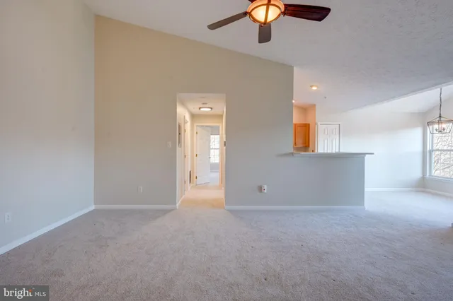 an empty room with a ceiling fan and window