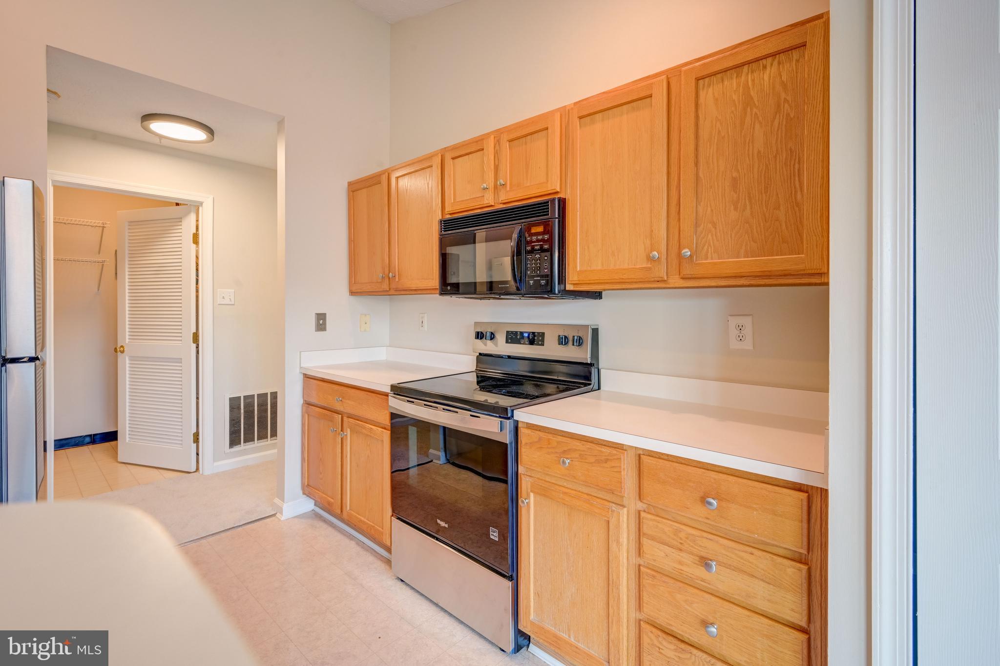 4933 Riders Court, Unit 4933 Owings Mills, MD 21117 - Photo 19 of 32 a kitchen with a stove and a microwave