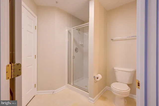 a bathroom with a granite countertop toilet and a shower