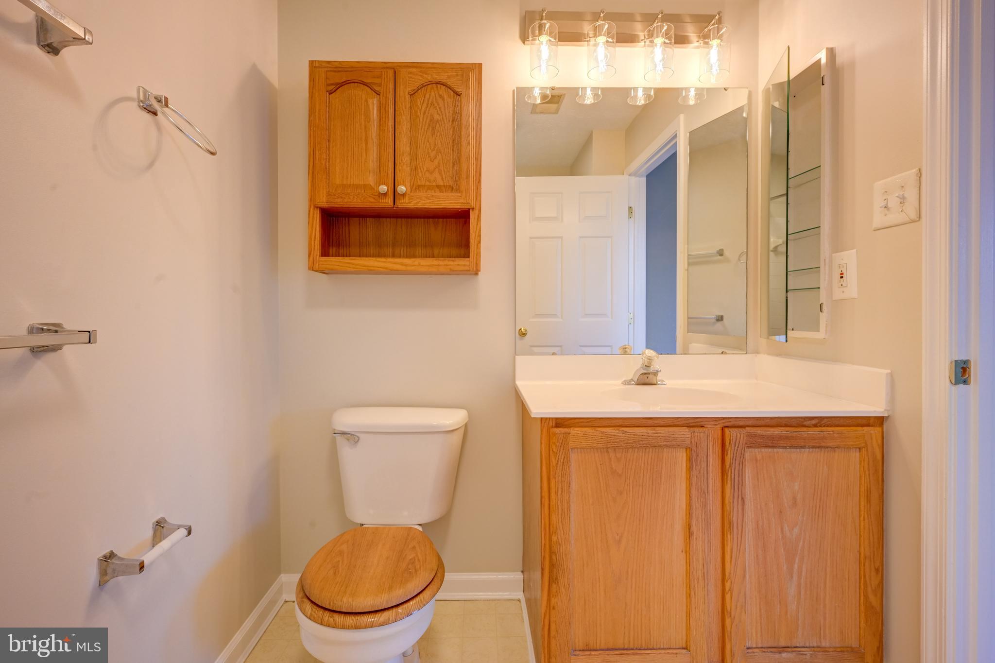 4933 Riders Court, Unit 4933 Owings Mills, MD 21117 - Photo 29 of 32 a bathroom with a granite countertop toilet and a sink