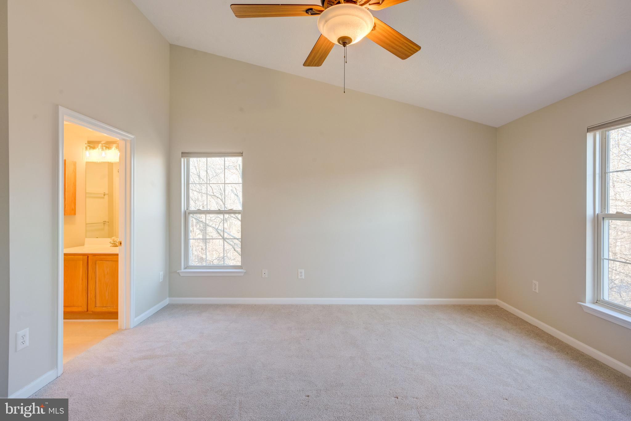 4933 Riders Court, Unit 4933 Owings Mills, MD 21117 - Photo 6 of 32 an empty room with windows and chandelier fan