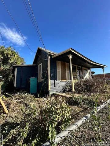 a front view of house with yard and trees around