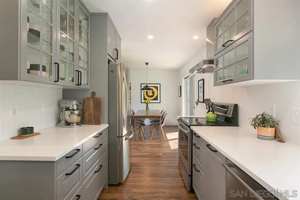 13637 Calais Drive Del Mar, CA 92014 - Photo 12 of 25 a kitchen that has a lot of cabinets a sink and wooden floor
