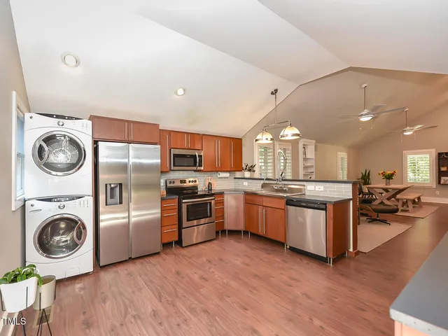a large kitchen with stainless steel appliances granite countertop a stove and a sink