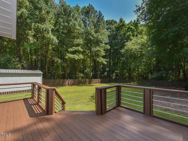 a view of a wooden deck and a backyard