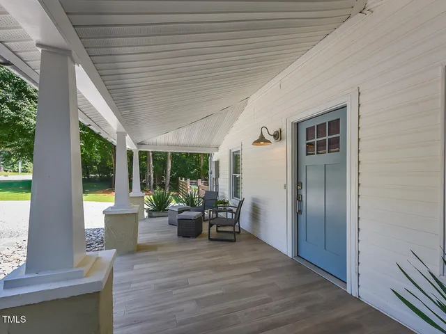 a view of a patio with table and chairs and wooden fence