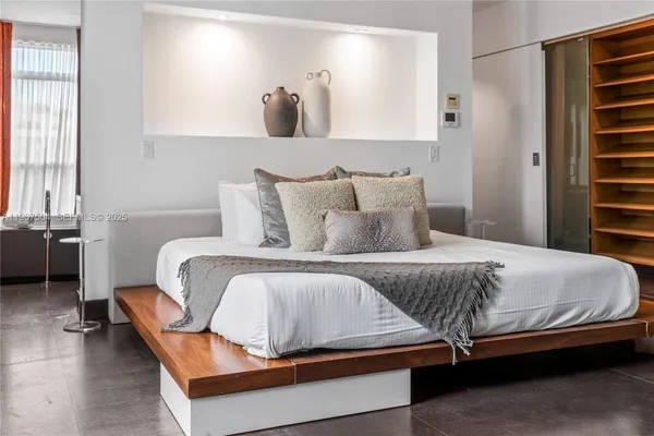 a bedroom with a bed and a painting on the wall