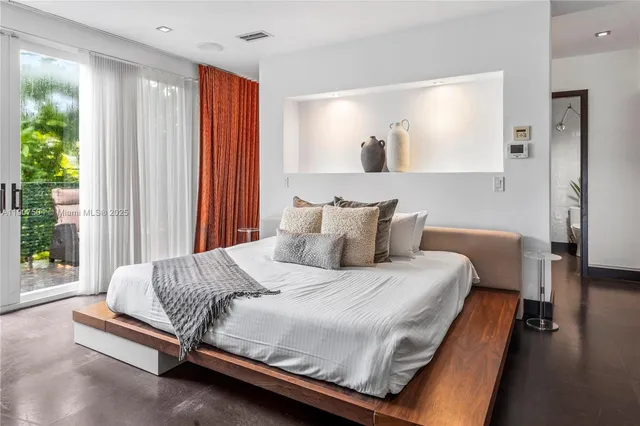 a bedroom with a bed and a painting on the wall