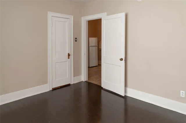 an empty room with wooden floor and closet