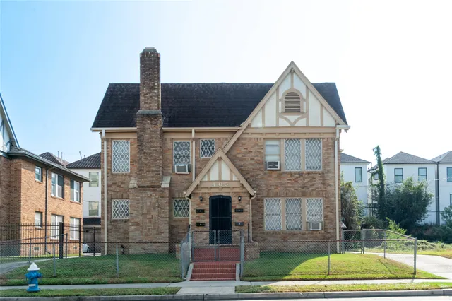 a view of a brick house next to a yard
