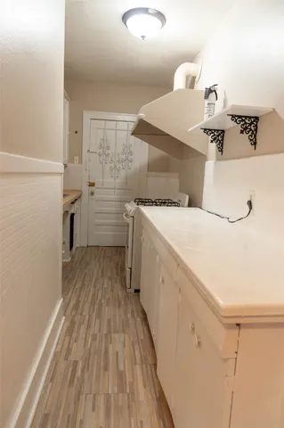 a storage room with wooden floor washer and dryer