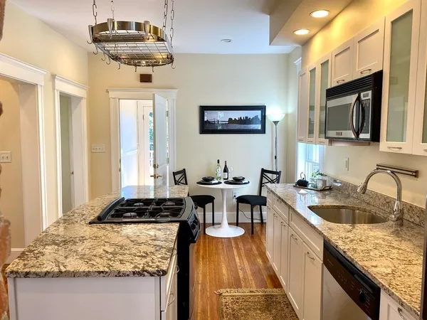 a kitchen with a counter space a sink stainless steel appliances and cabinets