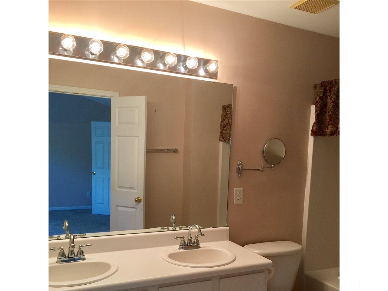 8520 Mt Valley Lane Raleigh, NC 27613 - Photo 8 of 10 a bathroom with a sink a toilet and mirror