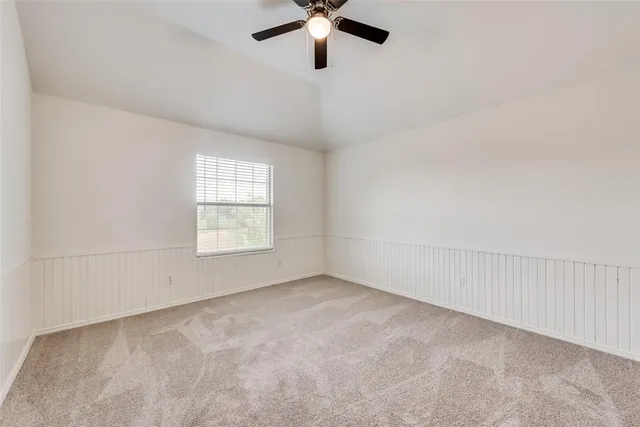 an empty room with a window and a ceiling fan