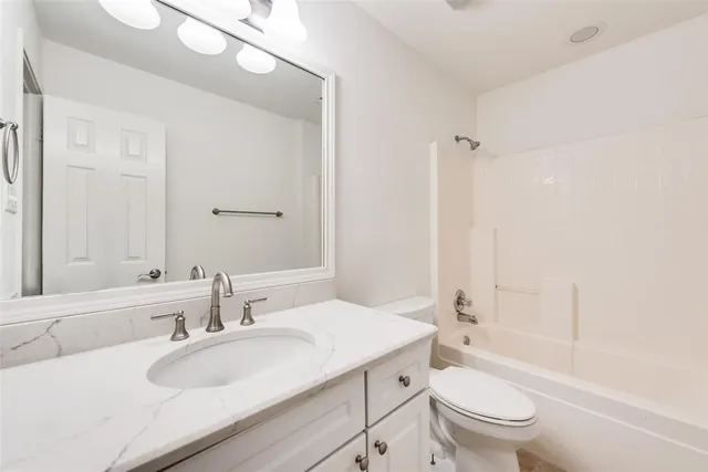 an empty room with a window and a ceiling fan