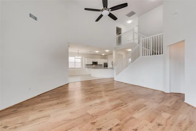 a view of an empty room and kitchen view