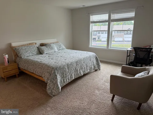 a spacious bedroom with a bed and couch