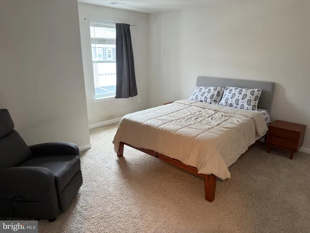a bed sitting in a bedroom next to a window