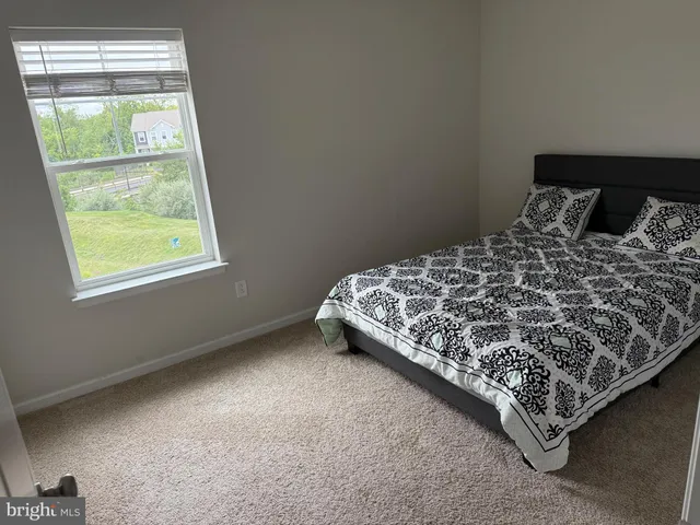 a bed sitting in a bedroom next to a window
