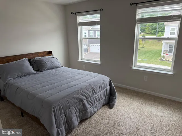 a bedroom with a bed and next to a window