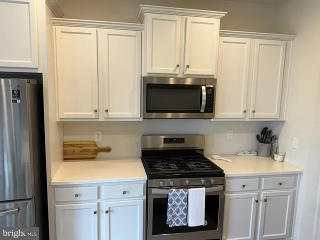 a kitchen with stainless steel appliances granite countertop a stove a microwave and cabinets