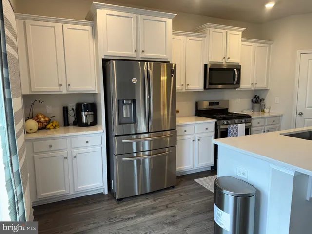 a kitchen with a refrigerator stove and white cabinets