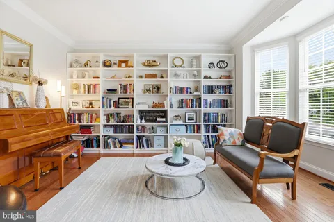 a living room with furniture and a dining table with wooden floor