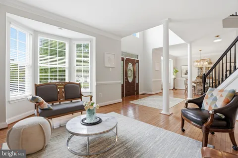 a view of a dining room and livingroom with furniture wooden floor a chandelier