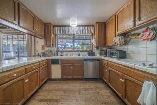a kitchen with kitchen island granite countertop a sink window and cabinets