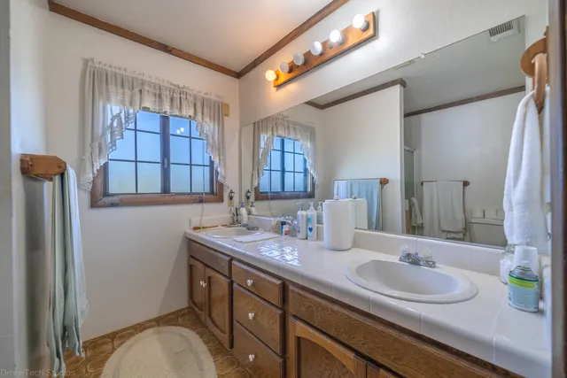 a bathroom with a granite countertop sink a mirror and a shower